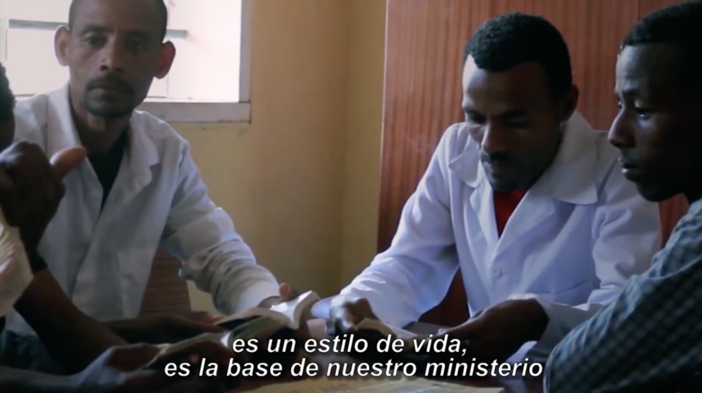 Obreros de SIM leen juntos alrededor de una mesa