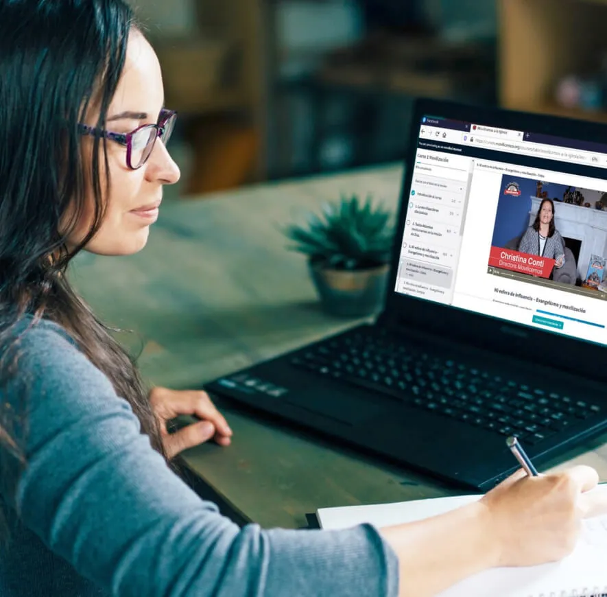 Una mujer toma apuntes frente a su laptop mientras sigue un curso online de Movilicemos